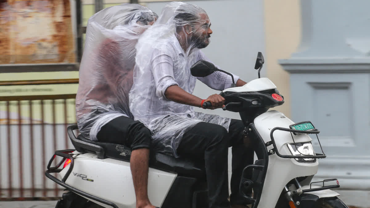 Commuters move through heavy monsoon rain in Prayagraj, Uttar Pradesh, on Wednesday.